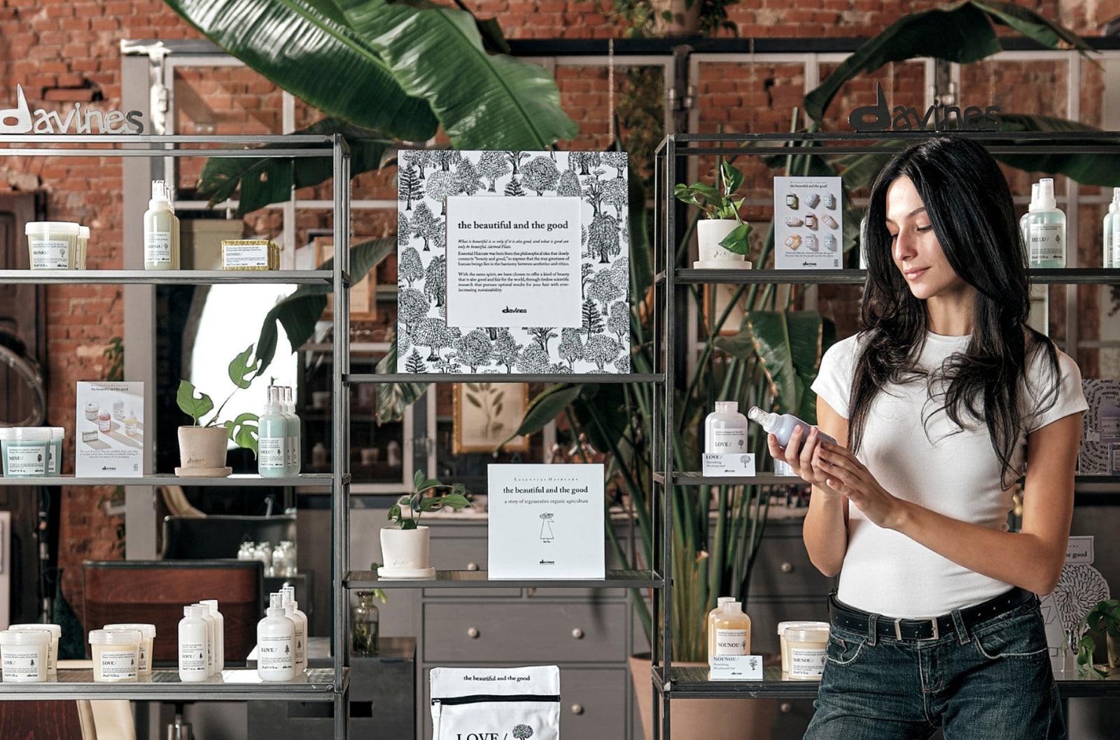 Woman inside Davines salon reading Essential Haircare products