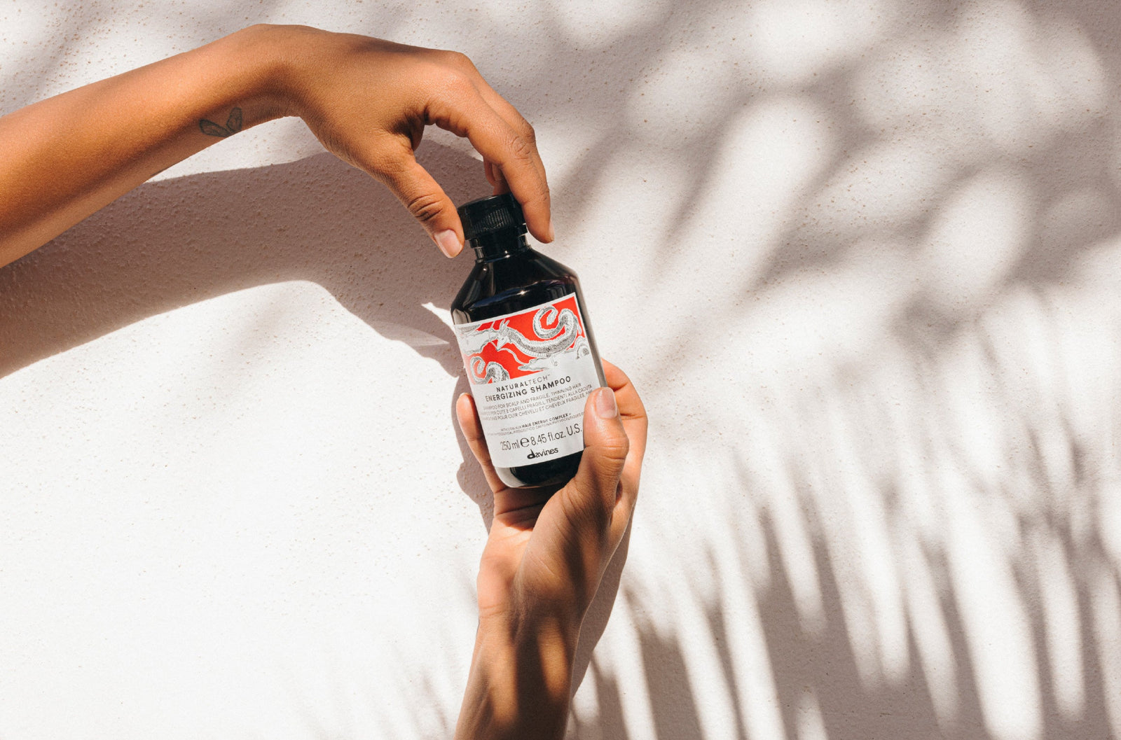 hands holding Davines ENERGIZING Shampoo